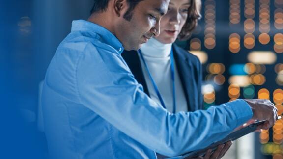 Close up of two employees looking at some data on the tab